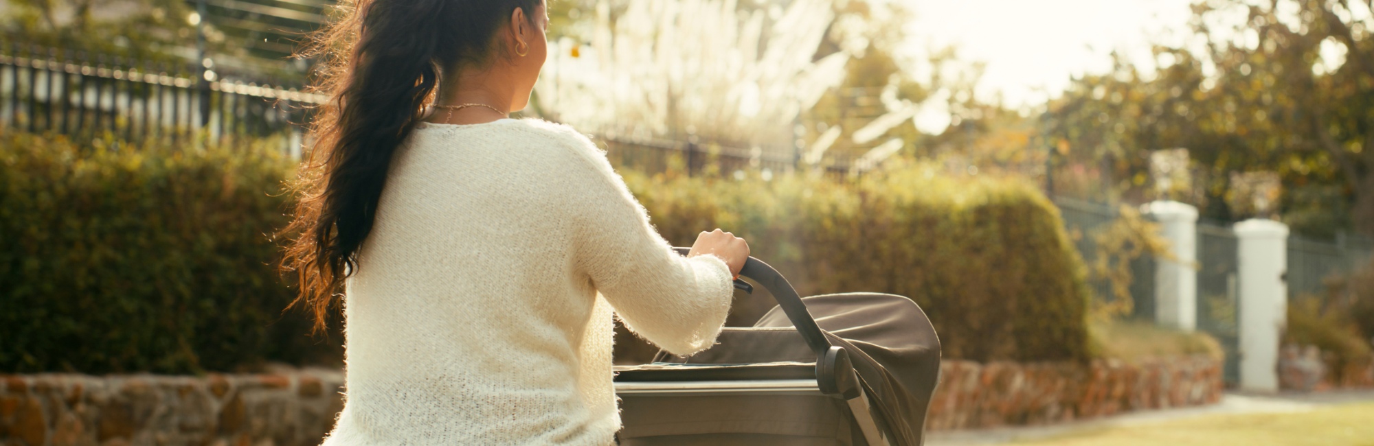 mother walks around outside pushing baby in pram