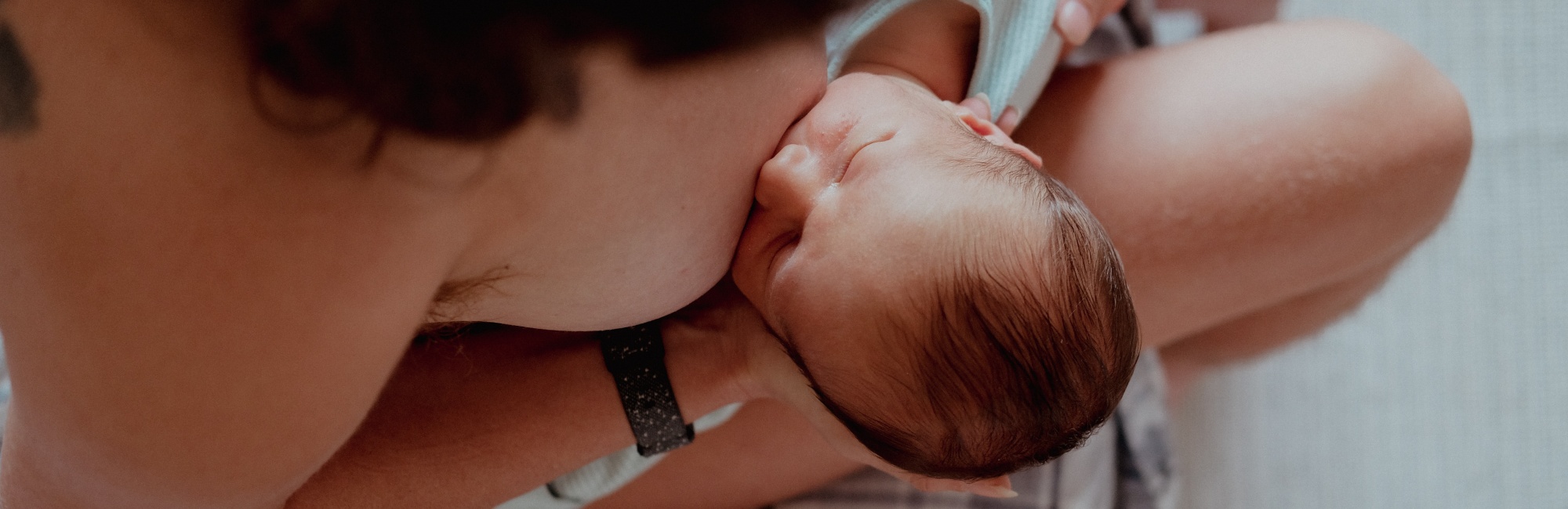 happily breastfeeding newborn baby