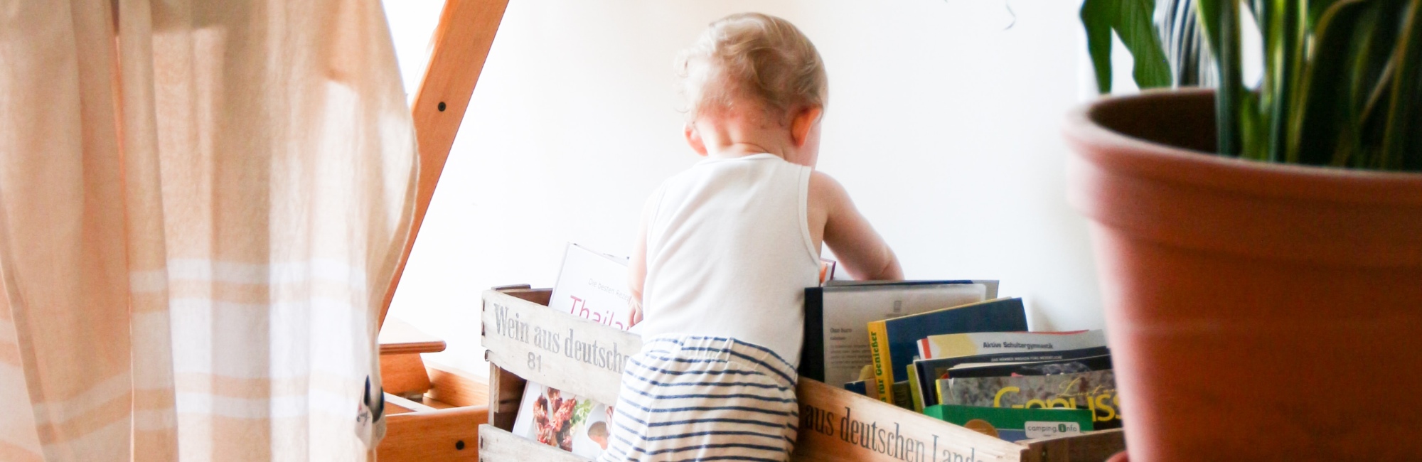 toddler playing in living room with books