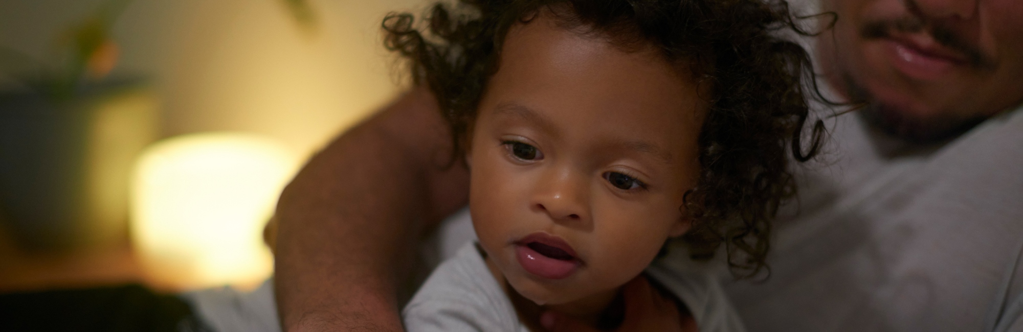 toddler and dad relaxing in bed